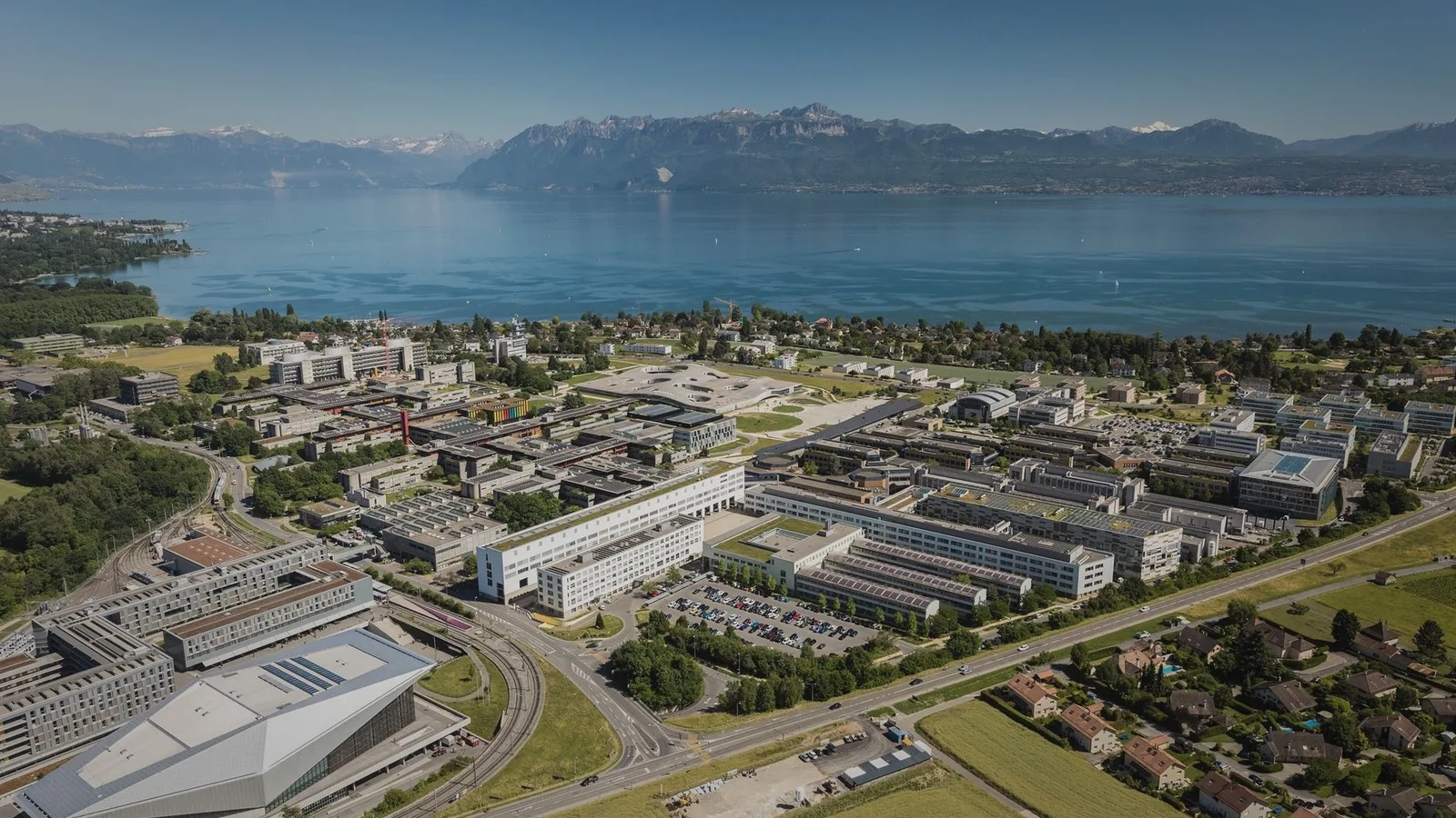 Aerial view of the EPFL campus beside Lake Geneva and the Alps