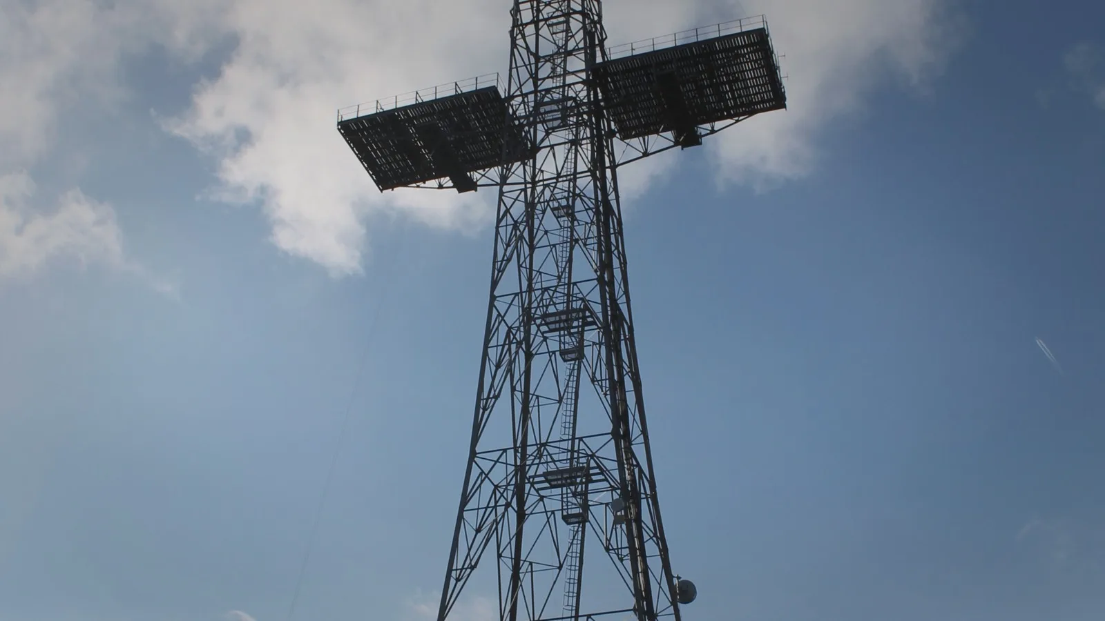 Tall radar mast and antenna array against the sky