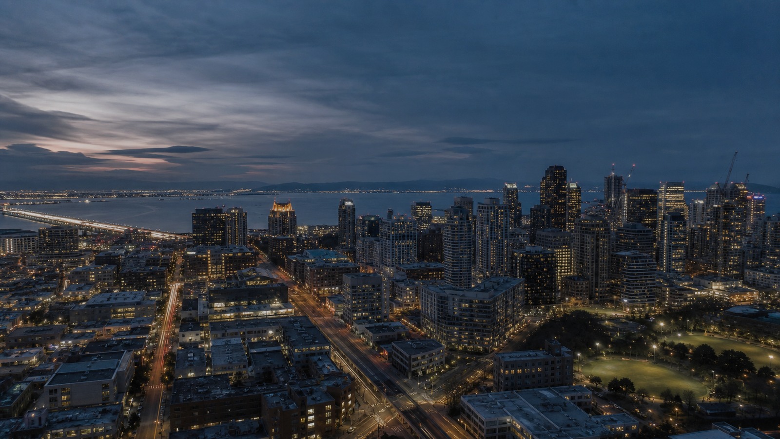 Modern city skyline at blue hour with open sky above.